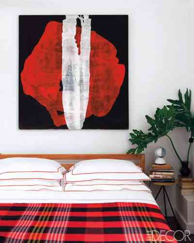 Plaid throw in this red and white room cia Elle Decor