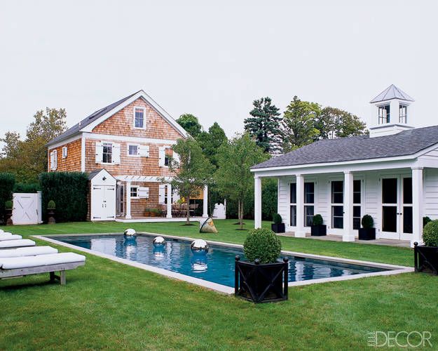 pool house surrounded by potted boxwood via Elle Decor